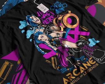 May include: Black t-shirt with a graphic print of two female characters from the video game League of Legends. The characters are Jinx and Vi, and the text "Arcane League of Legends" is printed on the bottom of the shirt.