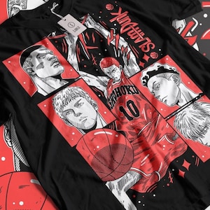 Può includere: Maglietta nera con una stampa grafica rossa e bianca di giocatori di basket dall'anime "Slam Dunk". La grafica presenta il testo "Slam Dunk" e il numero "10".