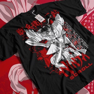 May include: Black t-shirt with a white graphic print of two anime characters fighting with swords. The text "NINJA SCROLL" is printed in red and white on the bottom of the shirt. The text "ヒルコの" is printed in white on the top of the shirt.