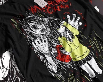 May include: Black t-shirt with a white and red graphic print of a girl with long black hair and a yellow sweater being chased by a monster with large eyes and a gaping mouth. The text "MERUKO CHAN" is printed in red on the shirt.