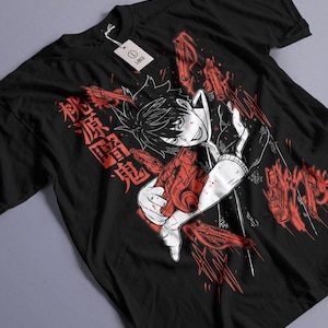 Könnte beinhalten: Schwarzes T-Shirt mit einer rot-weißen Grafik im Anime-Stil. Das Design zeigt eine Figur, die eine rote Waffe hält, japanischen Text und rote Waffenillustrationen. Ein weißes Etikett ist angebracht.