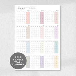 May include: A 2027 yearly wall planner featuring a clean grid layout for all twelve months. Each month is organized with days of the week and includes a subtle pastel-colored column for weekends. The text 2027 YEARLY WALL PLANNER is visible.