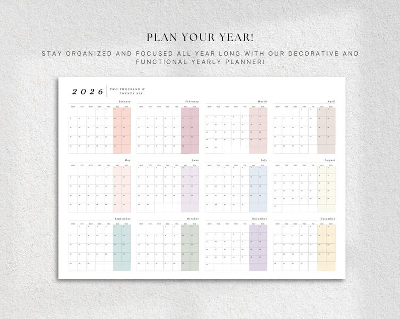 May include: A white 2026 yearly planner with a grid layout, featuring pastel-colored monthly highlights. The text "PLAN YOUR YEAR!" and "STAY ORGANIZED AND FOCUSED ALL YEAR LONG WITH OUR DECORATIVE AND FUNCTIONAL YEARLY PLANNER!" are displayed at the top.