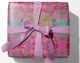 May include: A wrapped gift box featuring a vibrant floral pattern in shades of pink, green, and blue. The box is tied with a lavender satin ribbon and bow, creating a festive presentation. The gift wrap design includes a repeating pattern of stylized flowers.