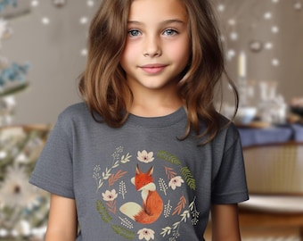 May include: A young person wearing a dark gray t-shirt with a graphic of a fox surrounded by flowers and leaves. The fox is orange and white.