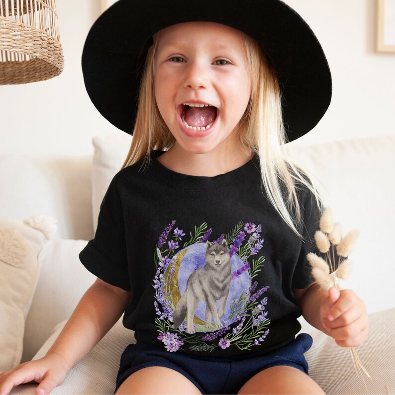 May include: A black t-shirt with a graphic of a wolf howling at the moon surrounded by purple flowers. The wolf is gray and white and the moon is blue and purple.