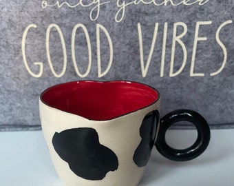 Handgemaakte keramische kopjes met koeienpatroon, ronde handvatten, rode binnenkant, zwart-witte buitenkant en hartvormig ontwerp voor koffieliefhebbers
