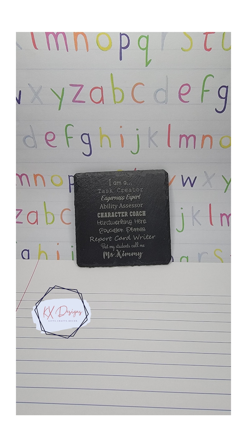 May include: A black slate coaster with an engraved message that reads "I am a... Task Creator, Eagerness Expert, Ability Assessor, CHARACTER COACH, Hardworking Hero, Education Planner, Report Card Writer, But my students call me Ms. Kimmy".