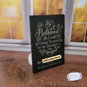 May include: Black slate plaque with a silver inscription that reads "He Believed He Could Change The World so he became a Principal". The plaque also has the text "MR. add name here PS 1330 The Bellerose School of Excellence".