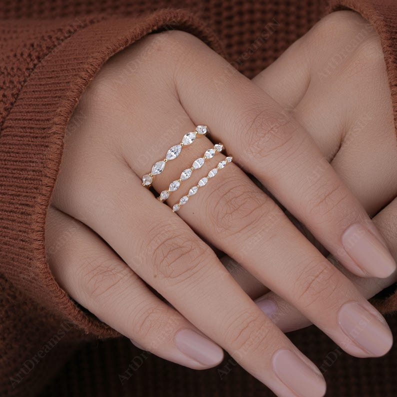 May include: Three gold rings with a row of marquise-shaped diamonds on each band.