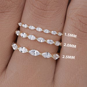 May include: Three gold eternity bands with marquise-shaped diamonds. The bands are 1.5mm, 2.0mm, and 2.5mm wide.