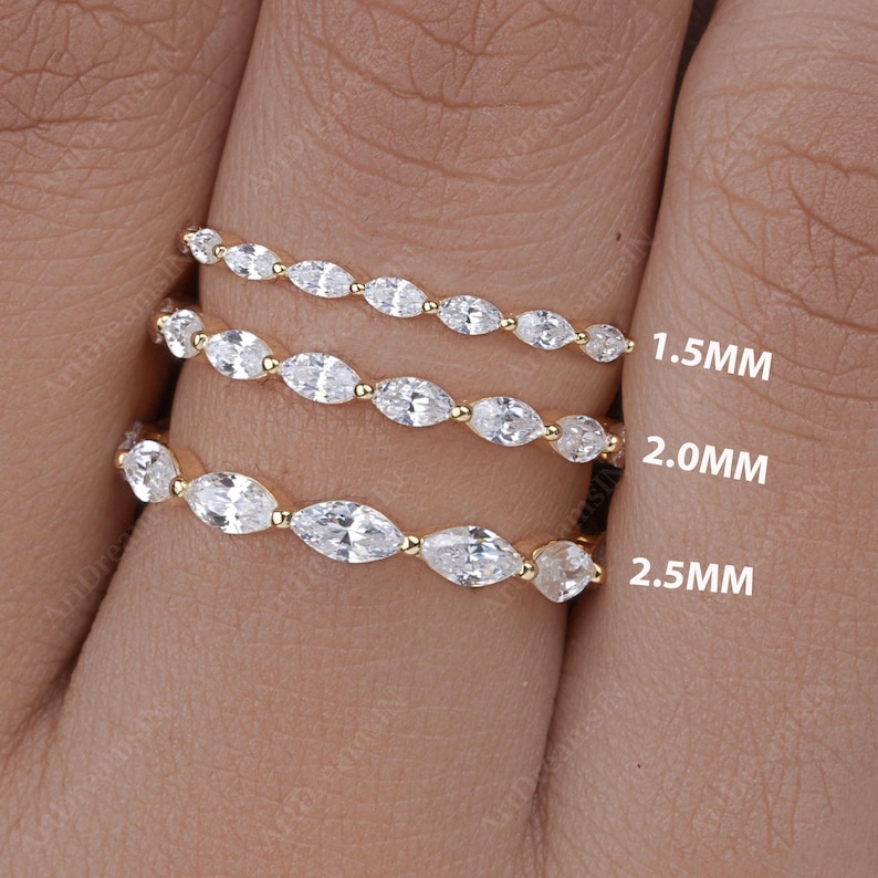May include: Three gold eternity bands with marquise-shaped diamonds. The bands are 1.5mm, 2.0mm, and 2.5mm wide.