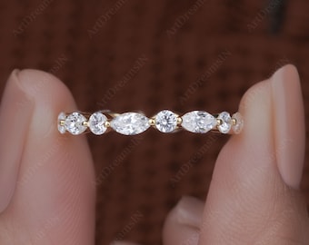 May include: A delicate gold band with a row of marquise and round diamonds. The band is set with a total of 10 diamonds.