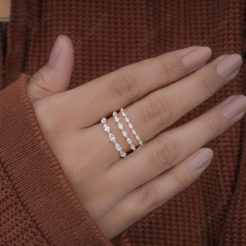 May include: Three delicate gold rings with a row of marquise-shaped diamonds set in each band.