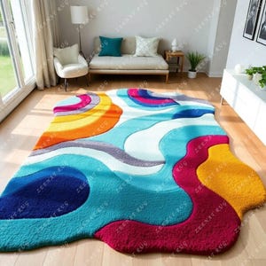 May include: Abstract area rug with a colorful, wavy design in shades of blue, yellow, red, orange, and gray. The rug has a unique, organic shape.
