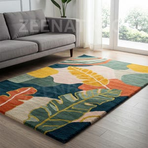 May include: A colorful area rug with a modern abstract design featuring large green, yellow, orange, and blue leaves on a cream background.
