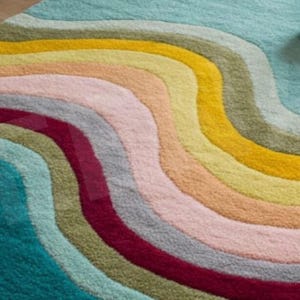 Puede incluir: Una alfombra colorida con un patr&oacute;n ondulado en tonos de azul, verde, amarillo, naranja, rosa y rojo.