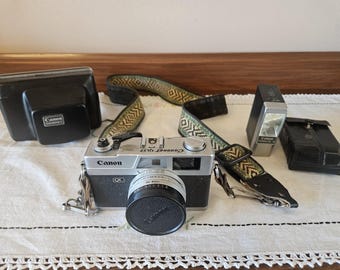 Vintage Canon Canonet QL17 35mm rangefinder camera with a 40mm f/1.7 lens, Canon Canolite D flash, cases and strap.