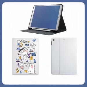 Puede incluir: Una funda negra para tableta con una tableta y un lápiz óptico, y dos fundas para tableta adicionales. Una funda blanca presenta un diseño de conejito de dibujos animados con helado y la palabra "Sorpresa". La otra funda es blanca lisa.