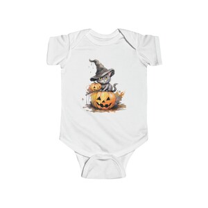 May include: A white baby onesie with a watercolor illustration of a gray cat wearing a witch's hat and sitting on a jack-o'-lantern.
