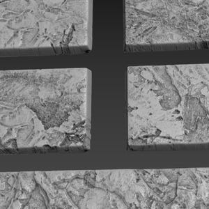 May include: Close-up of four gray, rectangular tiles with a rough, textured surface. The tiles are arranged in a grid pattern.