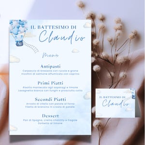 Può includere: Un menu e un biglietto da visita per battesimo azzurri con la scritta "IL BATTESIMO DI Claudio". Il menu presenta una mongolfiera con un elefante e una scala. Il menu include un elenco di piatti italiani.