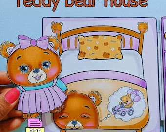 Puede incluir: Una actividad artesanal imprimible en PDF para niños con una casa de ositos de peluche. La imagen muestra un osito de peluche marrón con un lazo rosa y un vestido azul de pie frente a una cama rosa y marrón con una almohada que dice "Oso Lindo..." El osito de peluche en la cama está soñando con conducir un coche rojo con globos.