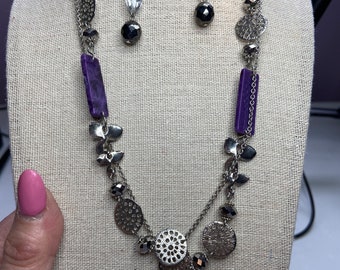 Silver tone chain with purple acrylic beads, silver tone discs & flowers and black / silver  sparkly beads.  1 pair of pierced earrings.