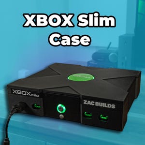 Pode incluir: Uma caixa de consola Xbox Slim Case preta com um logótipo circular verde da Xbox no topo. O painel frontal apresenta o texto XBOX PRO e ZAC BUILDS, um botão de energia central verde brilhante e duas portas de comando com detalhes verdes e um cabo preto.