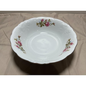 Puede incluir: Un tazón de porcelana blanca con un borde dorado y un diseño floral con rosas rosas y hojas verdes.