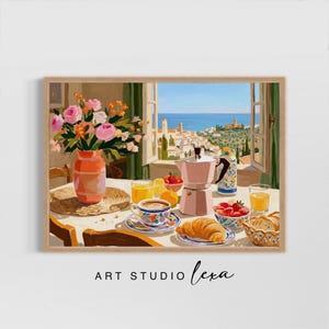 May include: A framed painting of a breakfast scene with a view. A pink coffee maker, a cup of coffee, croissants, and a vase of flowers are on a table. The window shows a coastal town and the sea. The text "ART STUDIO lexa" is at the bottom.