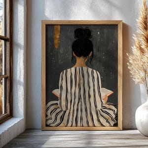 Pode incluir: Impressão artística emoldurada com uma pessoa lendo um livro. A figura, vista por trás, tem cabelo escuro em um coque e veste uma roupa listrada. O fundo é escuro com detalhes dourados. A moldura é de madeira.