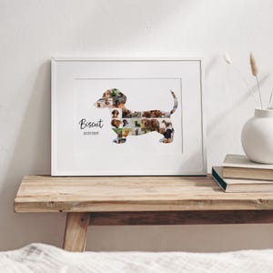 May include: A framed photo collage in the shape of a dachshund, filled with various dog photographs. The name "Biscuit" and the date 01/17/2015 are written in black script. The frame is white, resting on a wooden surface.