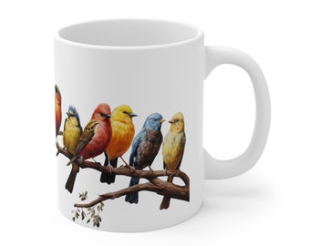 May include: White ceramic mug with a colorful illustration of seven birds perched on a branch. The birds are red, yellow, blue, and green.