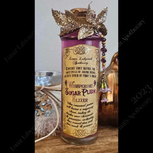 May include: A glass bottle with a pink liquid and a gold label that reads "Whispering Sugar Plum Elixir". The label also includes the text "A potion that blends the sweetness of sugar plums with a touch of fairy's magic". The bottle is decorated with a gold and purple fairy charm.