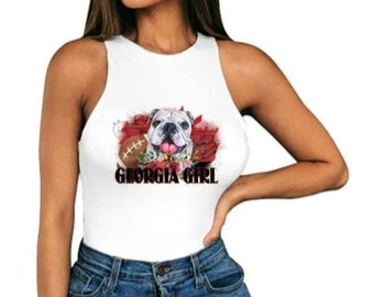 May include: White sleeveless tank top with a graphic of a bulldog holding a football and the text "Georgia Girl".