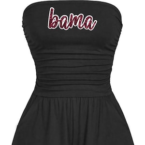 May include: Black strapless romper with a ruched bodice and shorts. The word "bama" is written across the chest in a glittery, cursive font. The romper has pockets.