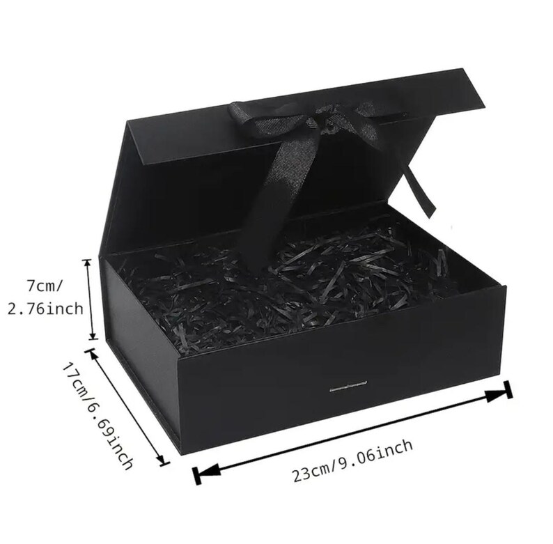 May include: A black rectangular gift box with a magnetic closure and a black ribbon bow. The box is open, revealing shredded paper inside. Dimensions are 9.06 inches long, 6.69 inches wide, and 2.76 inches high.