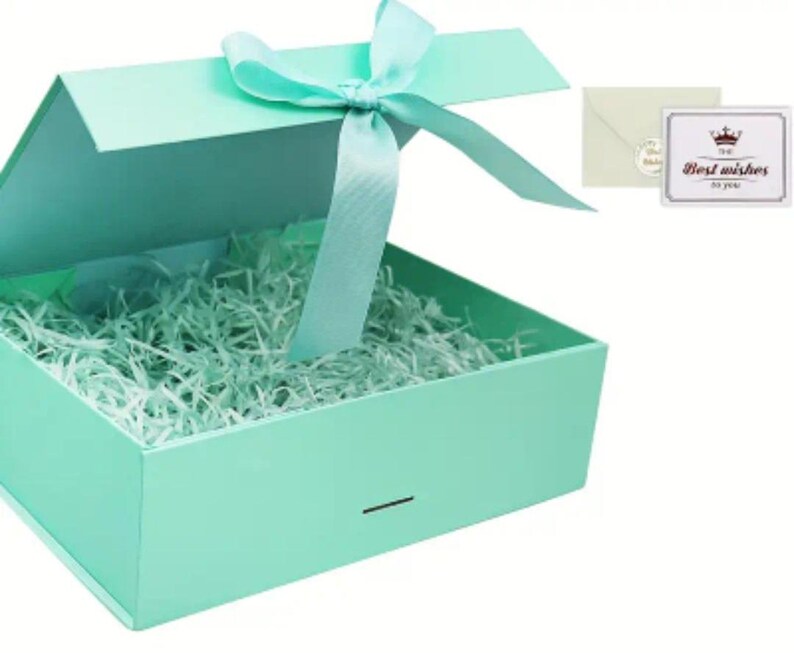 May include: An open, mint-green gift box with a matching ribbon tied in a bow. The box is filled with shredded paper and includes a small card that reads "Best wishes to you."