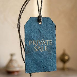Può includere: Un'etichetta rettangolare in carta testurizzata color verde ottanio scuro, appesa a un gancio di metallo rustico tramite uno spago marrone. L'etichetta riporta la scritta PRIVATE SALE in caratteri dorati centrati sulla parte frontale.