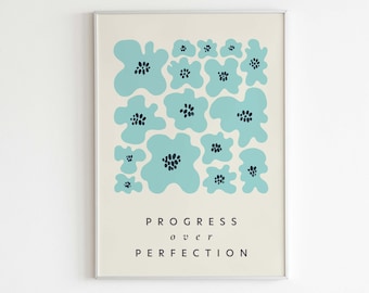 May include: A framed art print featuring a cream-colored background with a pattern of light blue abstract flowers. The text "PROGRESS over PERFECTION" is centered below the floral design. The words "LETTERS TO FUTURE SELF" are at the bottom.