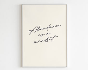 May include: A white framed print with black text that reads "Abundance is a mindset". The print is on a white wall and has the text "Letters to Future Self" at the bottom.