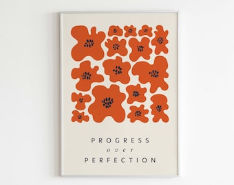 May include: A framed print with an abstract design of orange flowers with black centers. The print has the text "PROGRESS over PERFECTION" and "LETTERS TO FUTURE self" at the bottom.