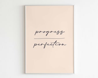 May include: A framed print with a peach background and black text that reads "progress over perfection". The text is in a handwritten font. The frame is silver and the print has the words "Letters to Future Self" at the bottom.
