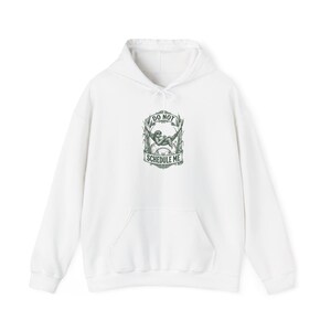 May include: White hoodie with a front pocket and drawstring hood. The front features a graphic with the text "DO NOT SCHEDULE ME" and an illustration of a person relaxing in a hammock. The graphic is in shades of green and gray.