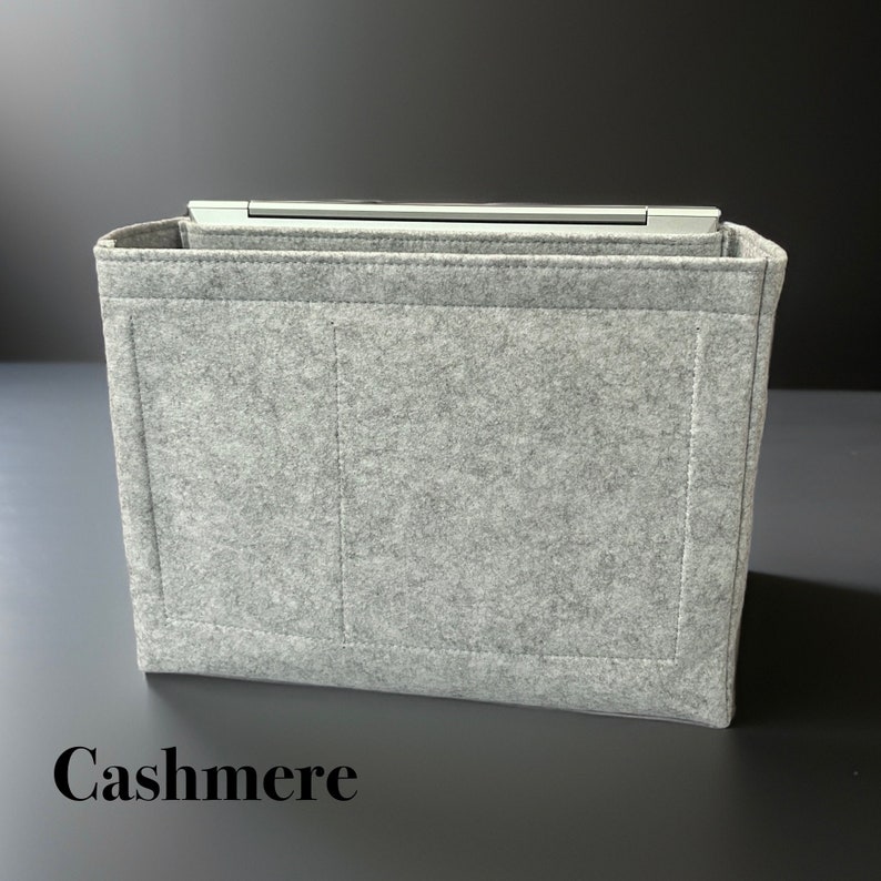 May include: A gray felt bag insert with two interior pockets and the word "Cashmere" printed on the bottom.