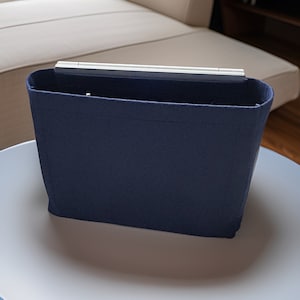 May include: A dark blue felt bag insert for a handbag. The insert has a rigid top and is designed to help organize a handbag.
