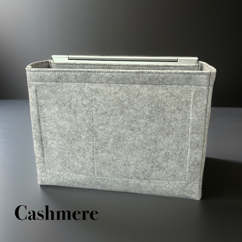 May include: A gray felt bag insert with two interior pockets and the word "Cashmere" printed on the bottom.