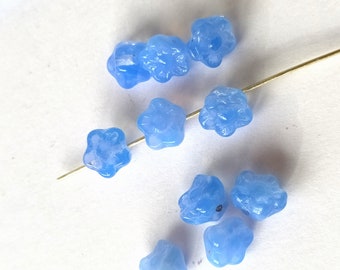 10 light blue glass beads in the shape of flowers