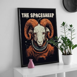 May include: A black framed poster with a white ram wearing an astronaut suit. The poster has the text "THE SPACESHEEP" at the top.